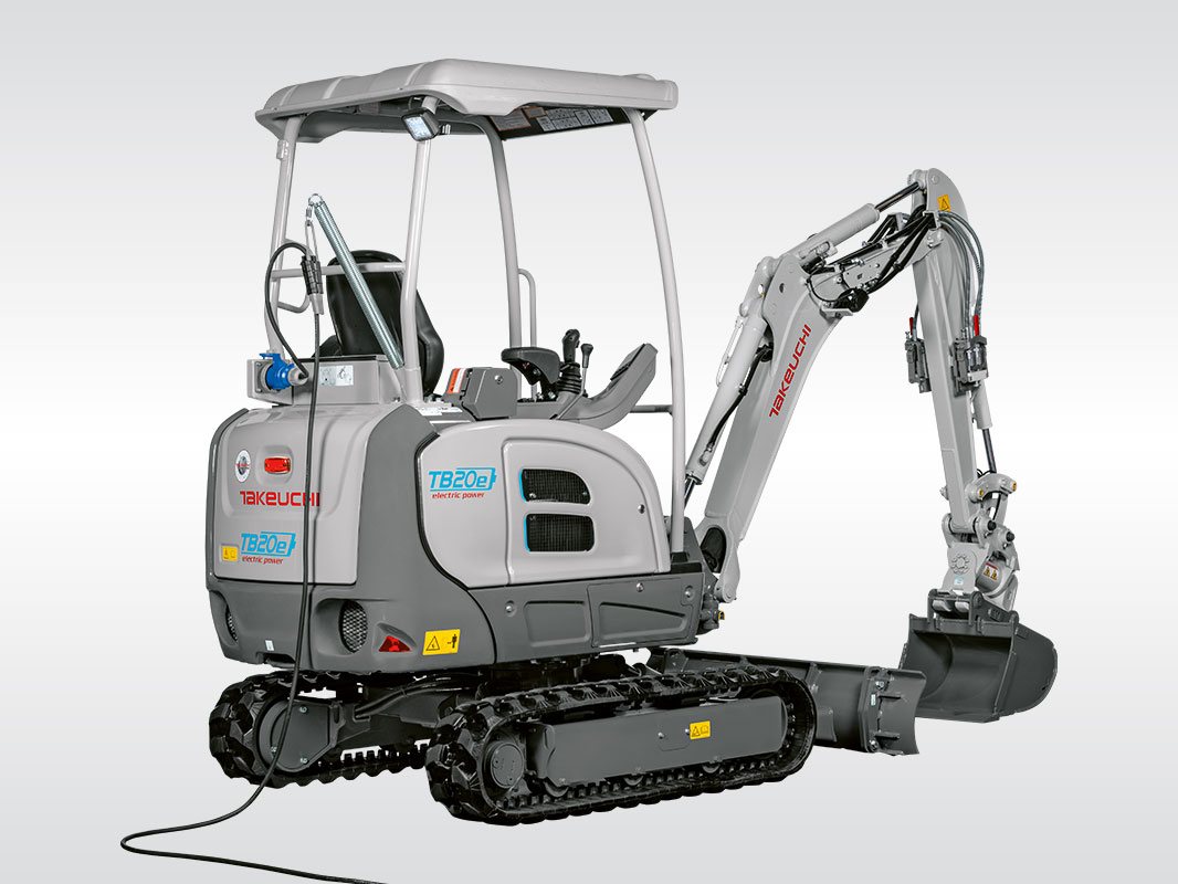 Grau-weißer Takeuchi Bagger TB 20e von hinten recht am Ladekabel angeschlossen
