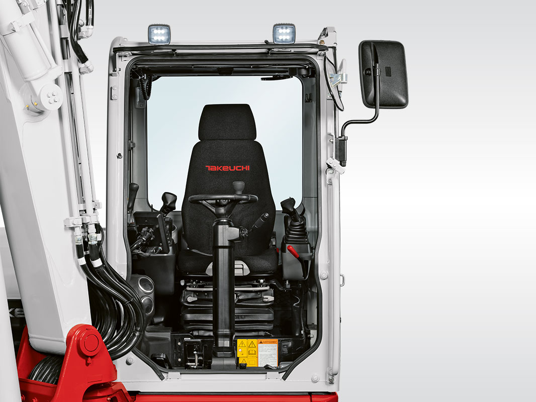 Ansicht der Kabine von vorne mit Lenkrad, Bedienelementen und Fahrersitz